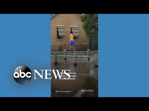You are currently viewing Man walks on stilts through flood waters