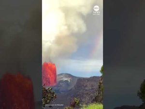 Read more about the article Erupting volcano and rainbow share sky in Hawaii